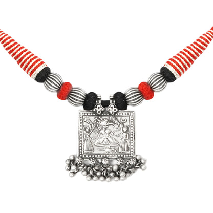 Close-up of Taveez handcrafted silver necklace pendant showing stamped silver detailing, silver beads, and ghungroos with black, red, and silver Bandhai threadwork — Studio Anivarya